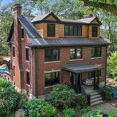 a aerial view of a house with a yard plants and large tree