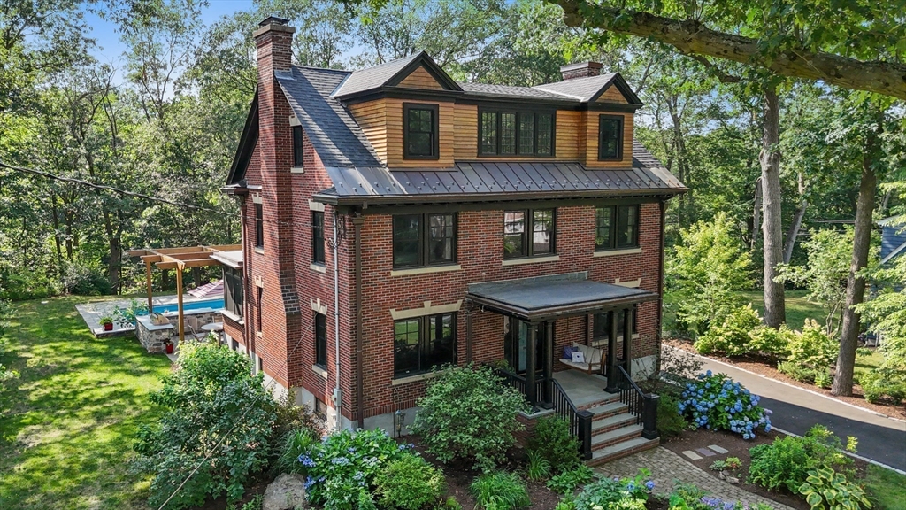 a aerial view of a house with a yard plants and large tree