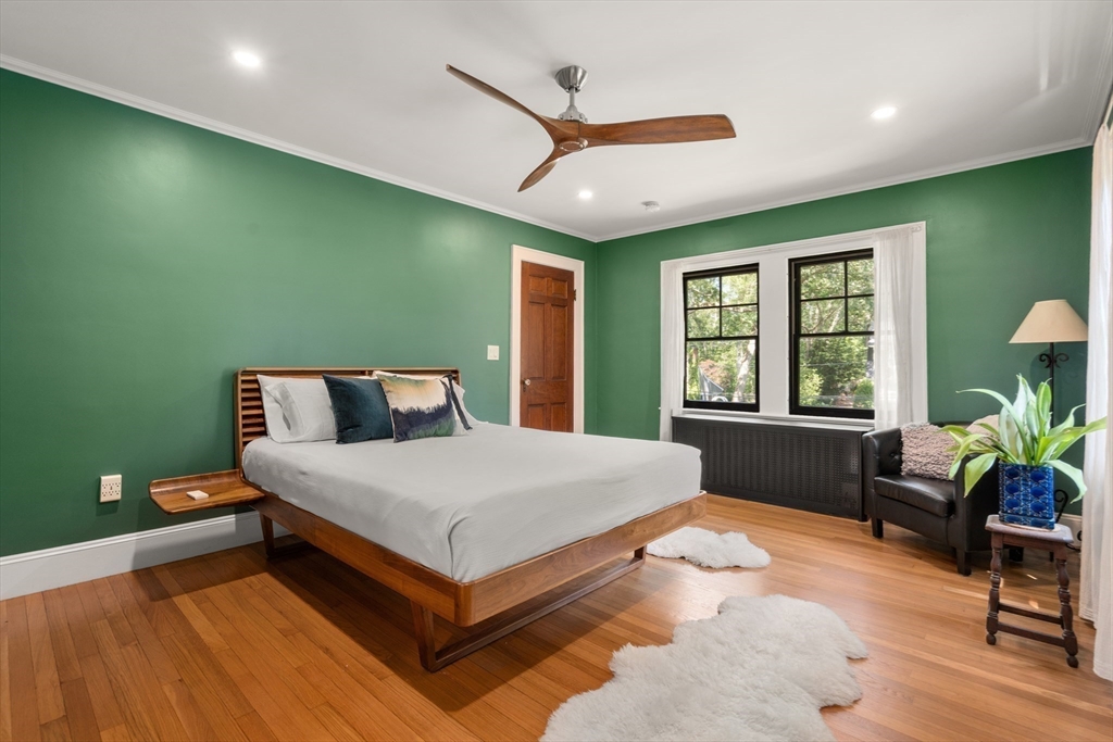 76 Cliff Road Milton, MA 02186 - Photo 18 of 36 a spacious bedroom with a bed and a table in it