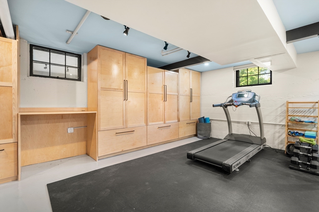 76 Cliff Road Milton, MA 02186 - Photo 29 of 36 a living room with furniture gym equipment and large window