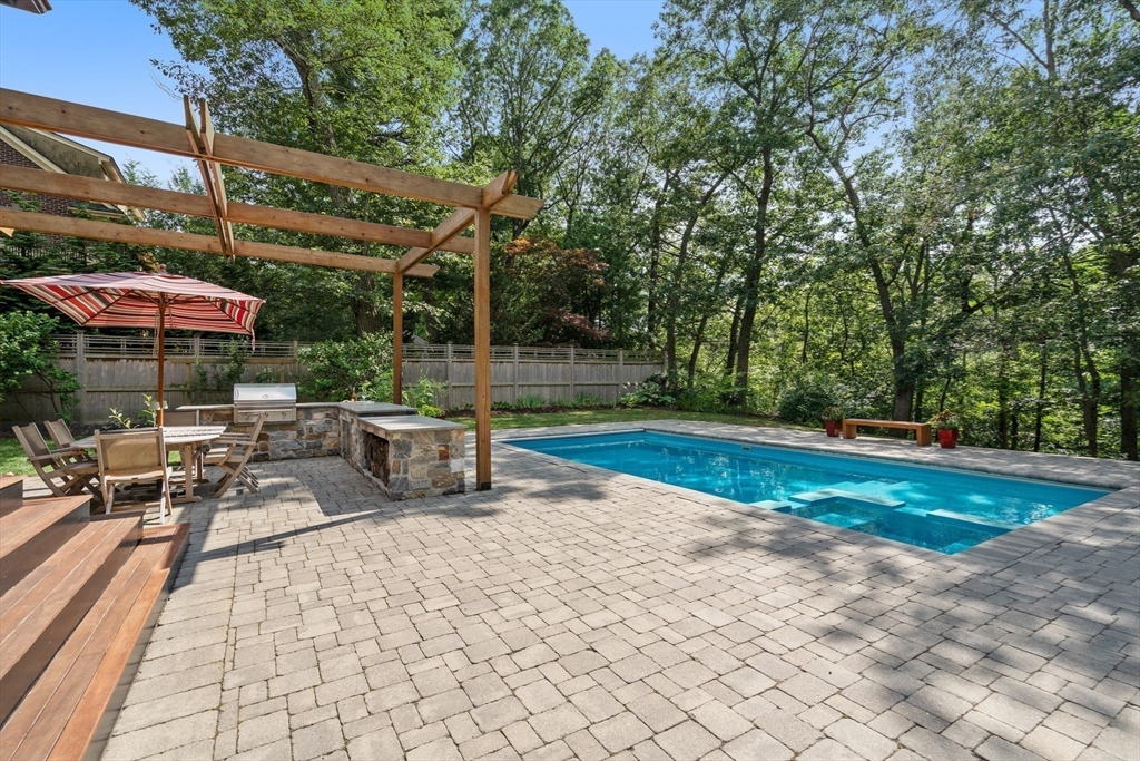 76 Cliff Road Milton, MA 02186 - Photo 32 of 36 a view of a patio with a table and chairs under an umbrella