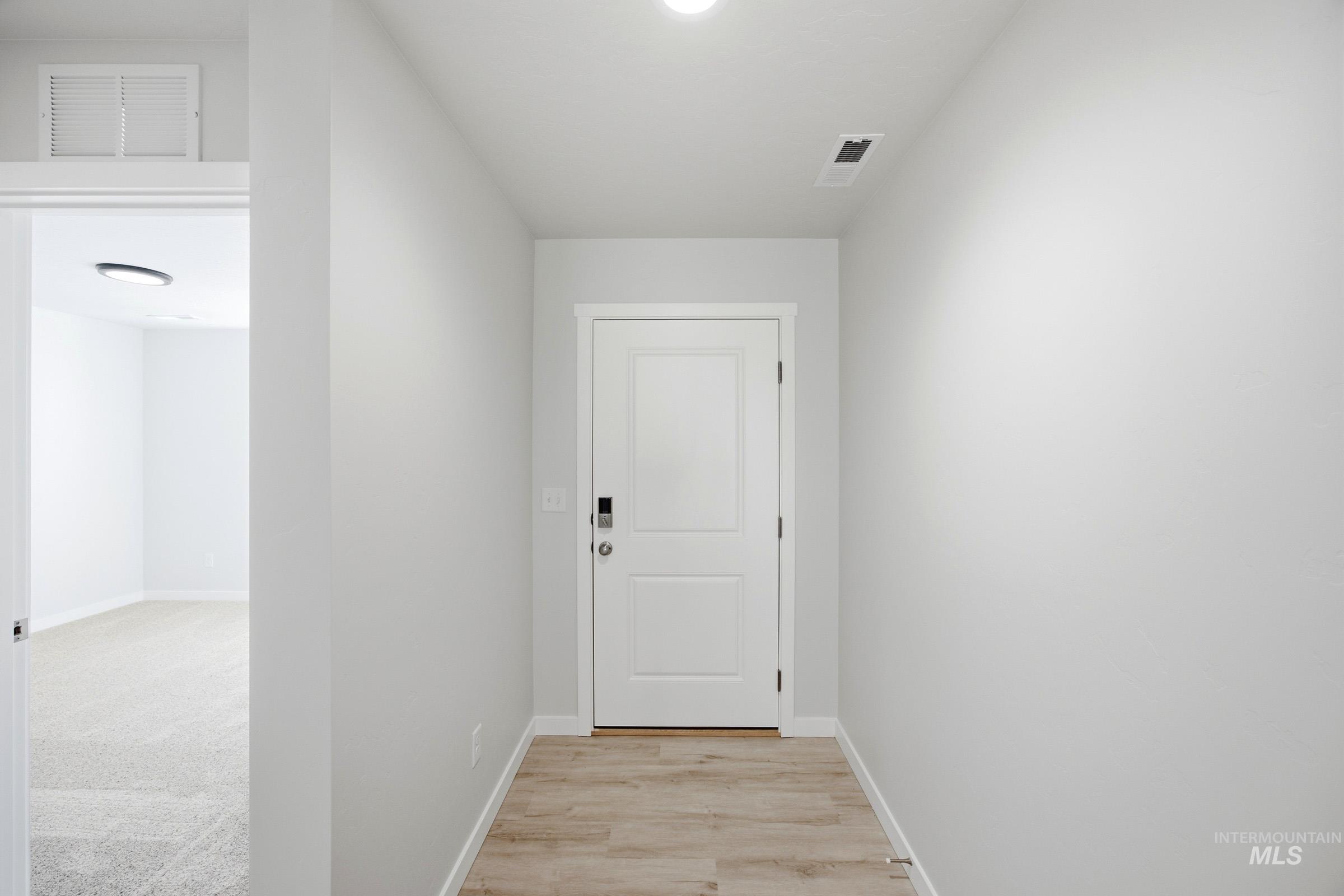 13298 Bank Street Caldwell, ID 83607 - Photo 2 of 23 Entryway with wood-finish flooring and a paneled door featuring modern hardware