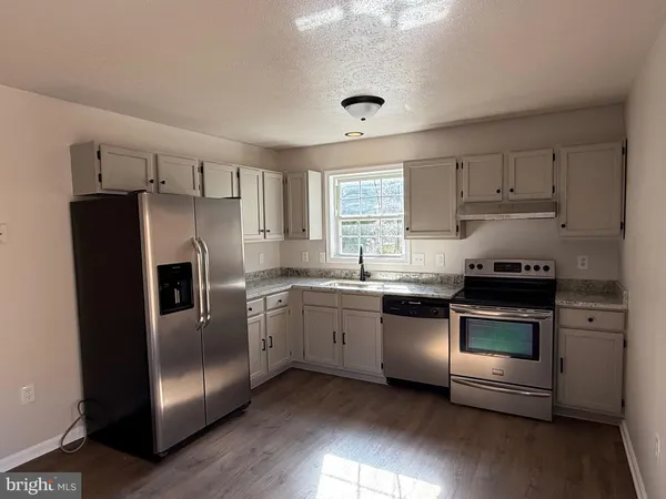 a kitchen with granite countertop stainless steel appliances and wooden cabinets