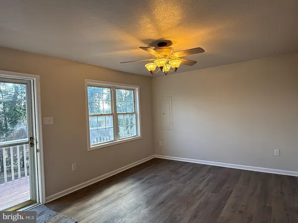 an empty room with a window and a chandelier