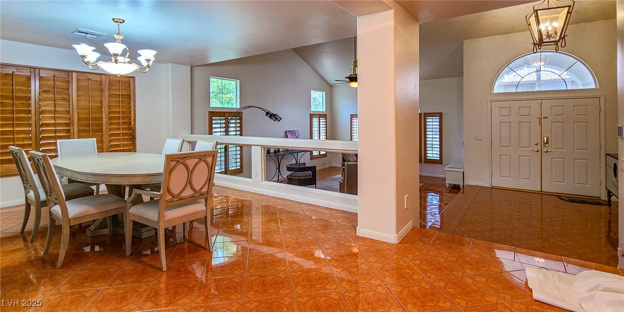 4100 Highland Castle Court Las Vegas, NV 89129 - Photo 14 of 49 Tiled dining area featuring a chandelier, vaulted ceiling, and ceiling fan