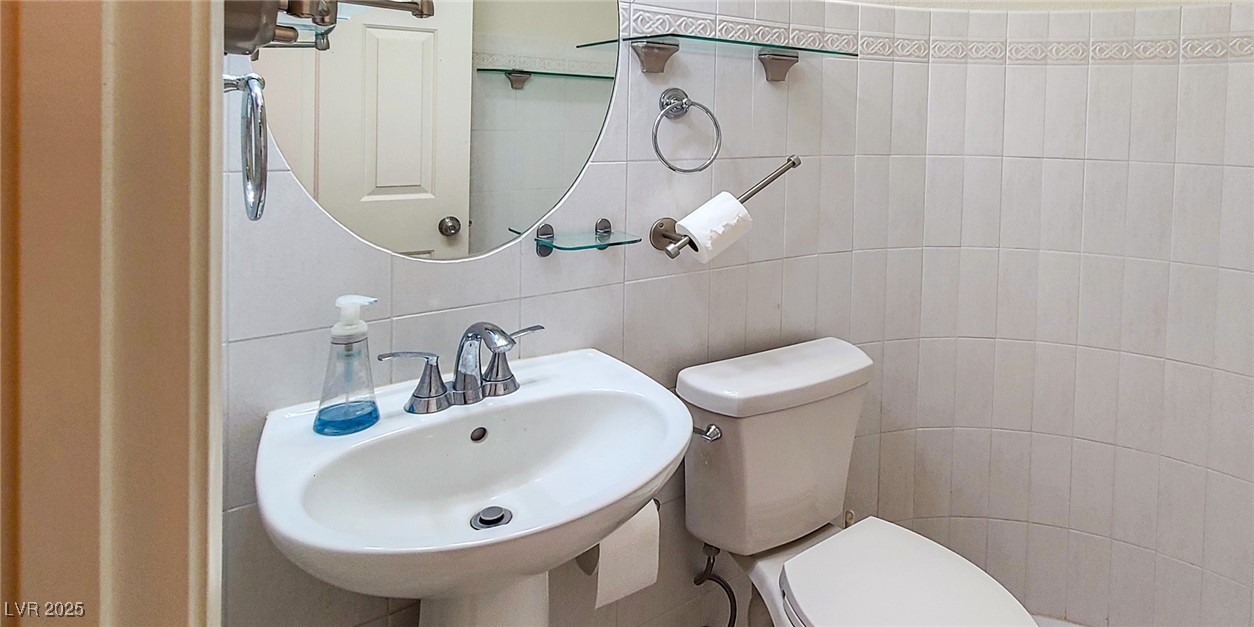 4100 Highland Castle Court Las Vegas, NV 89129 - Photo 16 of 49 Half bath with tile walls and a sink