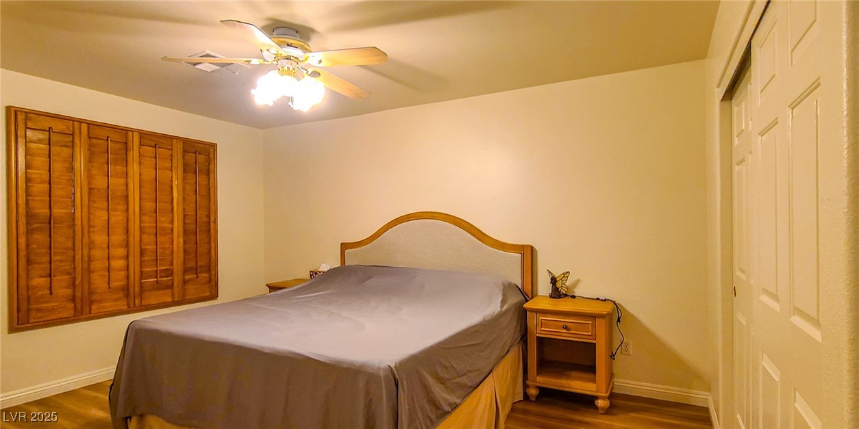 4100 Highland Castle Court Las Vegas, NV 89129 - Photo 19 of 49 Bedroom with dark wood-style flooring, a ceiling fan, and a closet