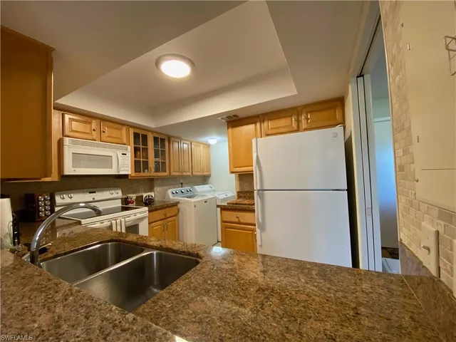 a kitchen with a sink appliances and cabinets