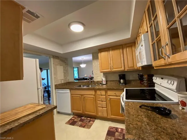a kitchen with a sink a stove and cabinets