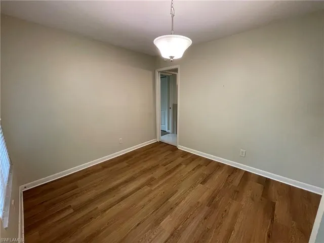 a view of room with wooden floor and ceiling fan