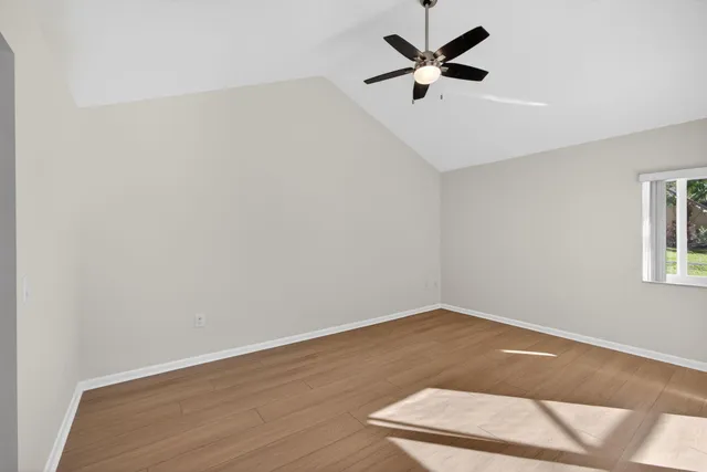 an empty room with a window and a ceiling fan