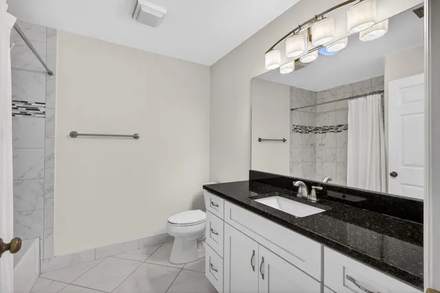 a bathroom with a double vanity sink a toilet and a mirror