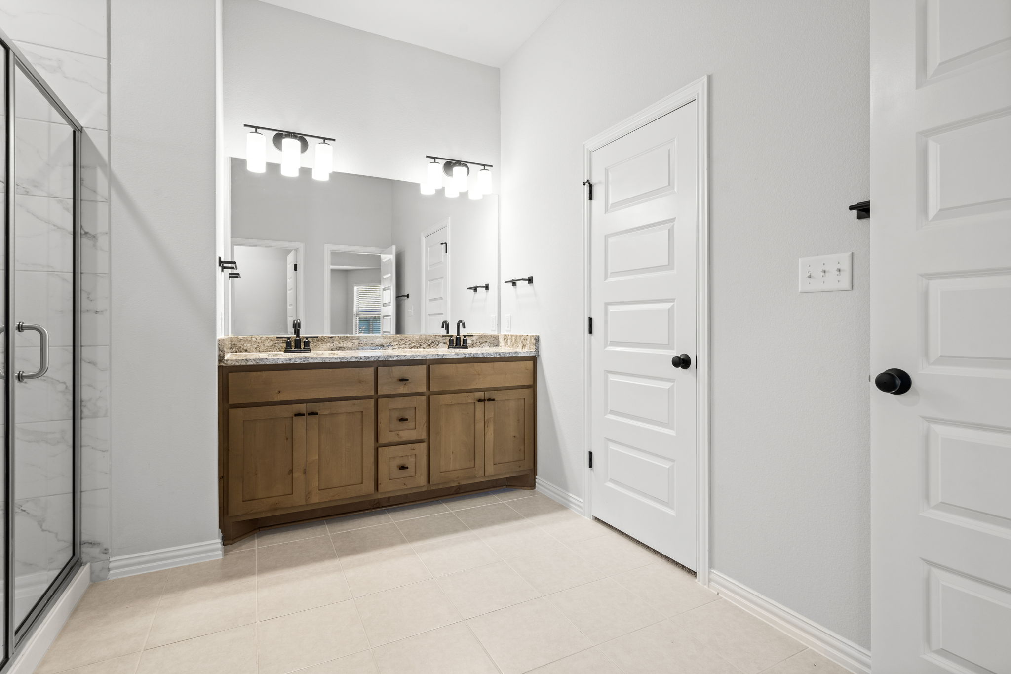 341 Fawn Riv Run Kyle, TX 78640 - Photo 13 of 29 Full bath featuring a sink, double vanity, a marble finish shower, and baseboards