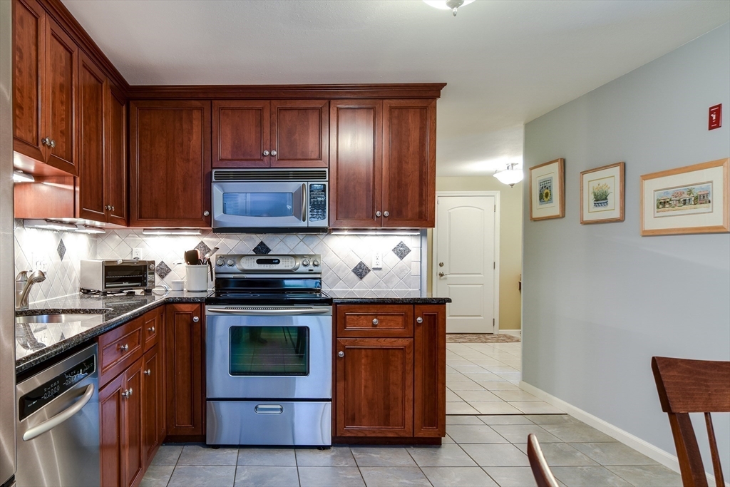38 Stagecoach Drive Ashland, MA 01721 - Photo 10 of 29 a kitchen with wooden cabinets and stainless steel appliances