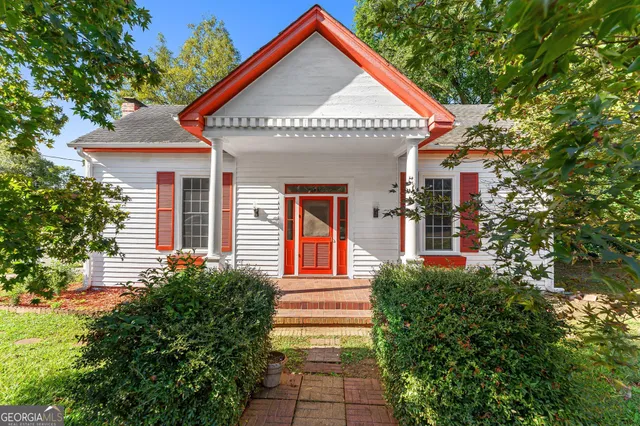 a view of a house with potted plants and a tree