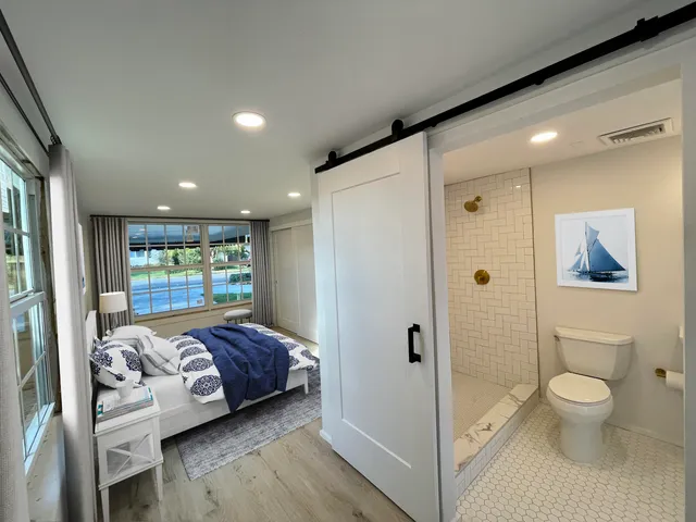 a view of bedroom with a large window and wooden floor