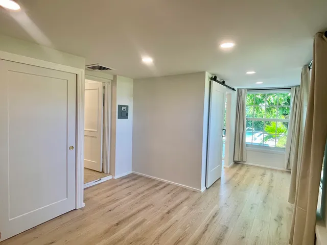 a view of hallway with a large window and wooden floor