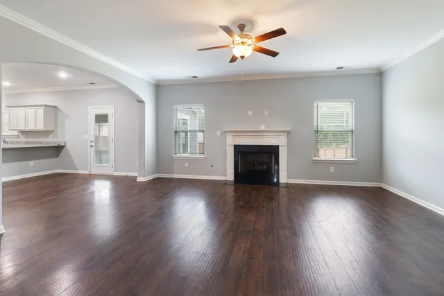 wooden floor fireplace and windows in an empty room