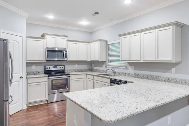 a kitchen with white cabinets and white appliances