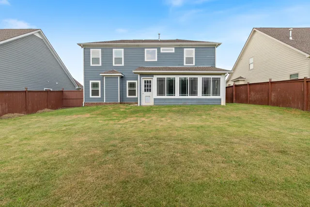 a big yard with large trees and a wooden fence