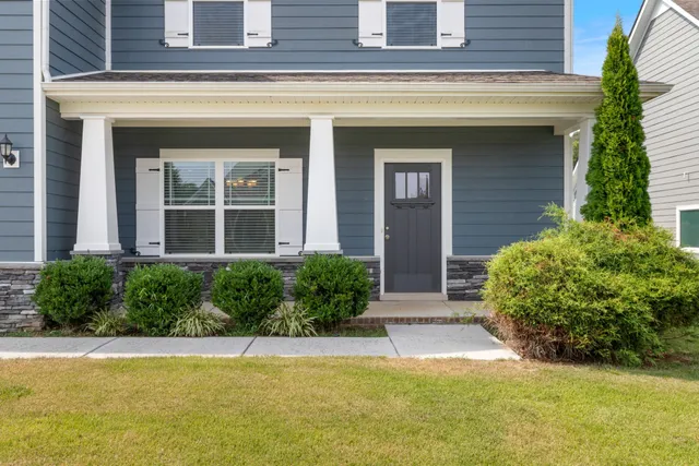 a view of a house with potted plants and a fountain