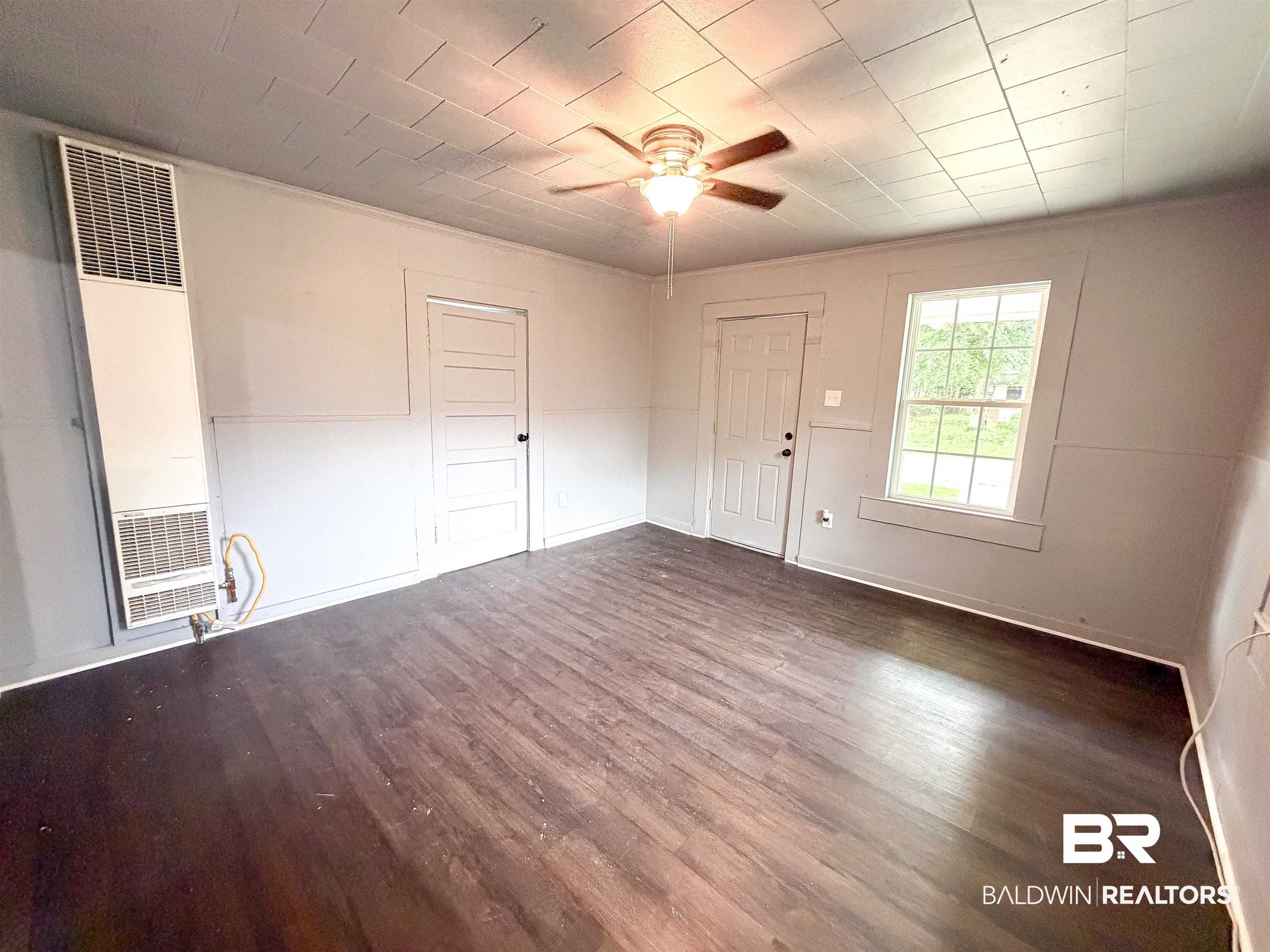 38 Flock Avenue Mobile, AL 36610 - Photo 3 of 27 Spacious room featuring wood-finish flooring, a ceiling fan with integrated lighting, and multiple windows providing natural illumination