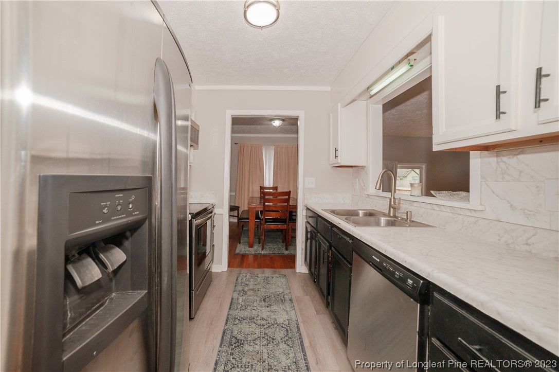 6005 Dalton Road Fayetteville, NC 28314 - Photo 20 of 44 a kitchen with granite countertop a sink stove and cabinets