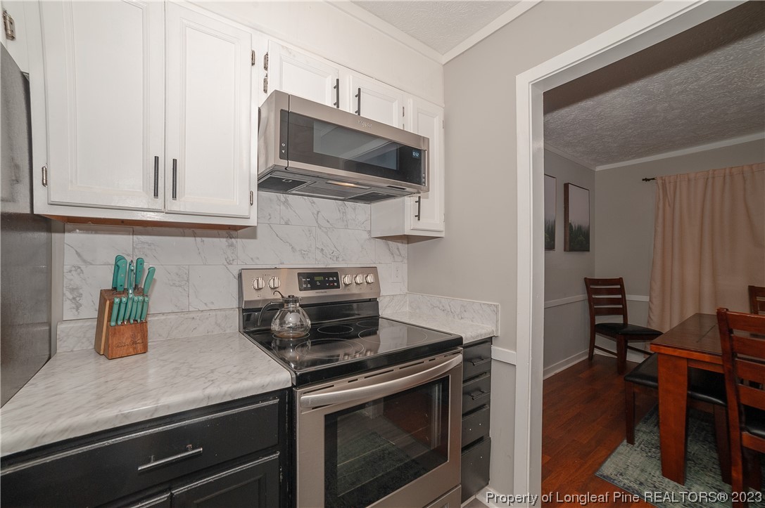 6005 Dalton Road Fayetteville, NC 28314 - Photo 23 of 44 a kitchen with stainless steel appliances a stove a microwave and cabinets