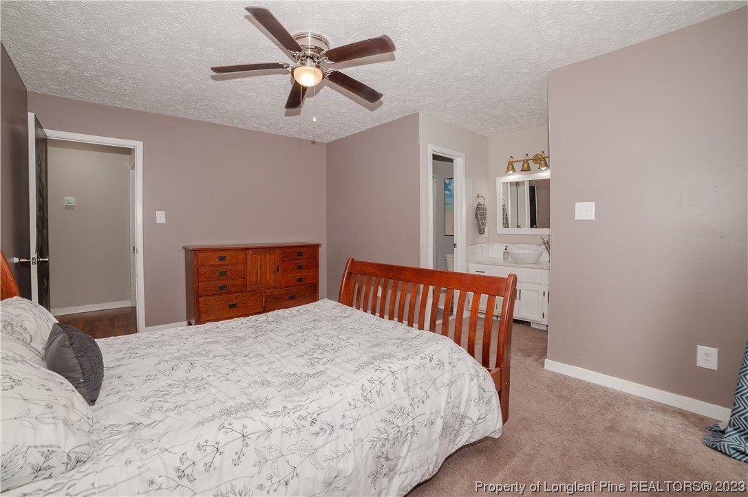 6005 Dalton Road Fayetteville, NC 28314 - Photo 28 of 44 a bedroom with a bed and a chandelier