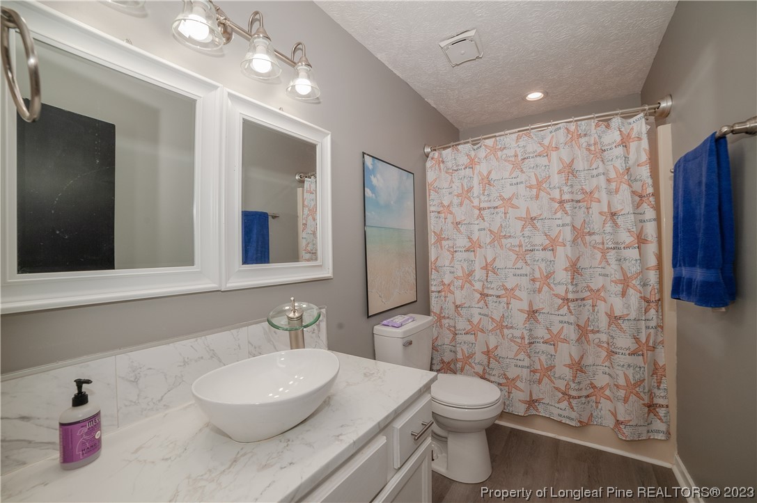 6005 Dalton Road Fayetteville, NC 28314 - Photo 41 of 44 a bathroom with a granite countertop toilet sink and mirror