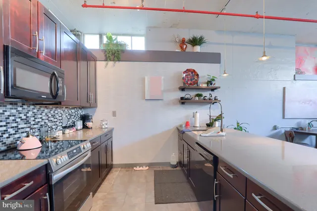 a kitchen with stainless steel appliances granite countertop a sink stove and cabinets