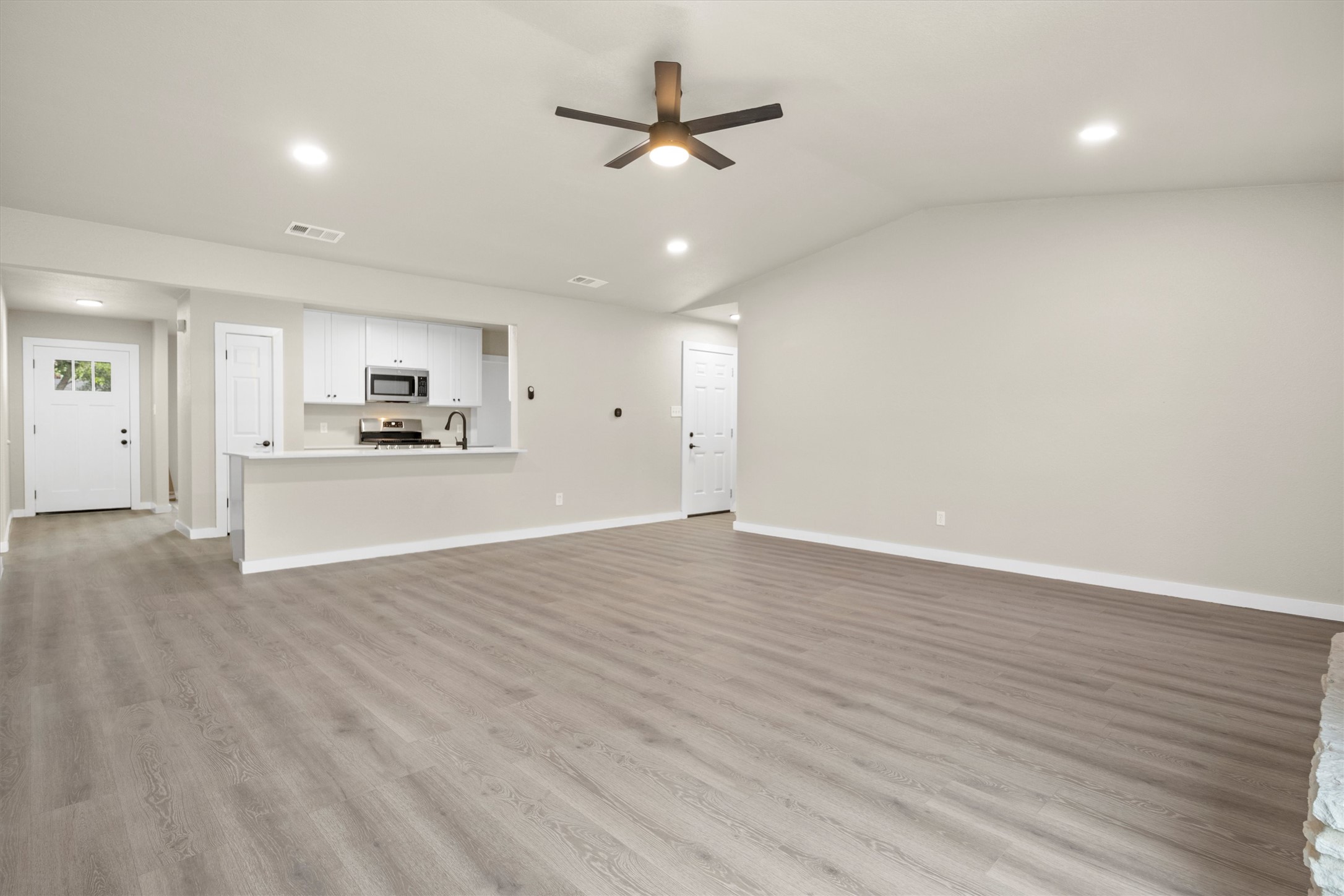 502 Pin Tail Lane Taylor, TX 76574 - Photo 15 of 26 Spacious living area featuring wood-finish flooring and a contemporary ceiling fan