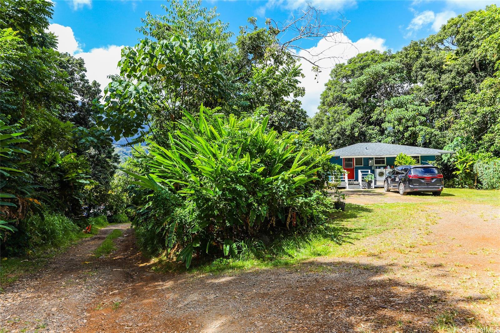 47-270 Ahuimanu Road Kaneohe, HI 96744 - Photo 11 of 25 a yellow house with trees in front of it
