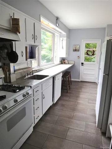a kitchen with a stove sink and cabinets