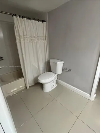 a bathroom with a toilet and a shower curtain