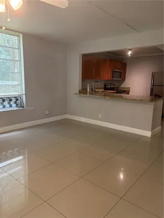 a living room with stainless steel appliances kitchen island granite countertop a sink and a stove top oven