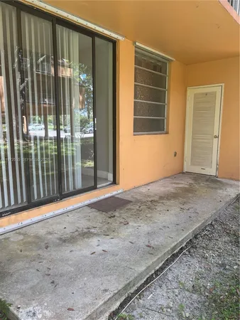 a view of backyard with sliding door and wooden floor