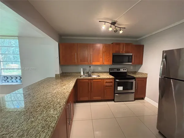 a kitchen with a stove a refrigerator and a sink