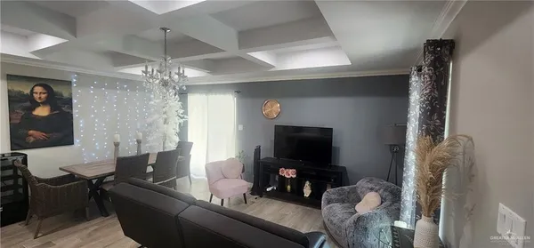 a living room with furniture a flat screen tv and a chandelier