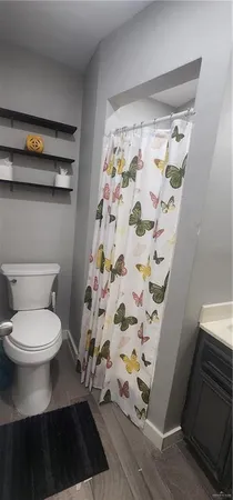 a bathroom with a toilet and a shower curtain