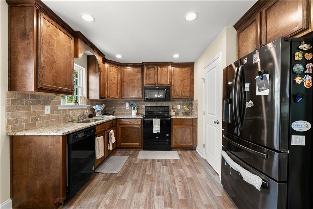 5430 Stepstone Way Gainesville, GA 30506 - Photo 12 of 39 a kitchen with stainless steel appliances granite countertop a refrigerator and a stove top oven