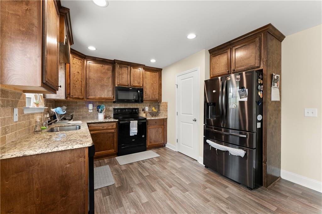 5430 Stepstone Way Gainesville, GA 30506 - Photo 13 of 39 a kitchen with granite countertop stainless steel appliances and wooden cabinets