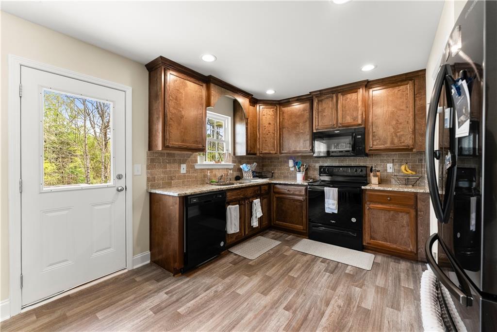 5430 Stepstone Way Gainesville, GA 30506 - Photo 14 of 39 a kitchen with stainless steel appliances granite countertop a refrigerator a sink dishwasher a stove and a microwave oven with wooden floor