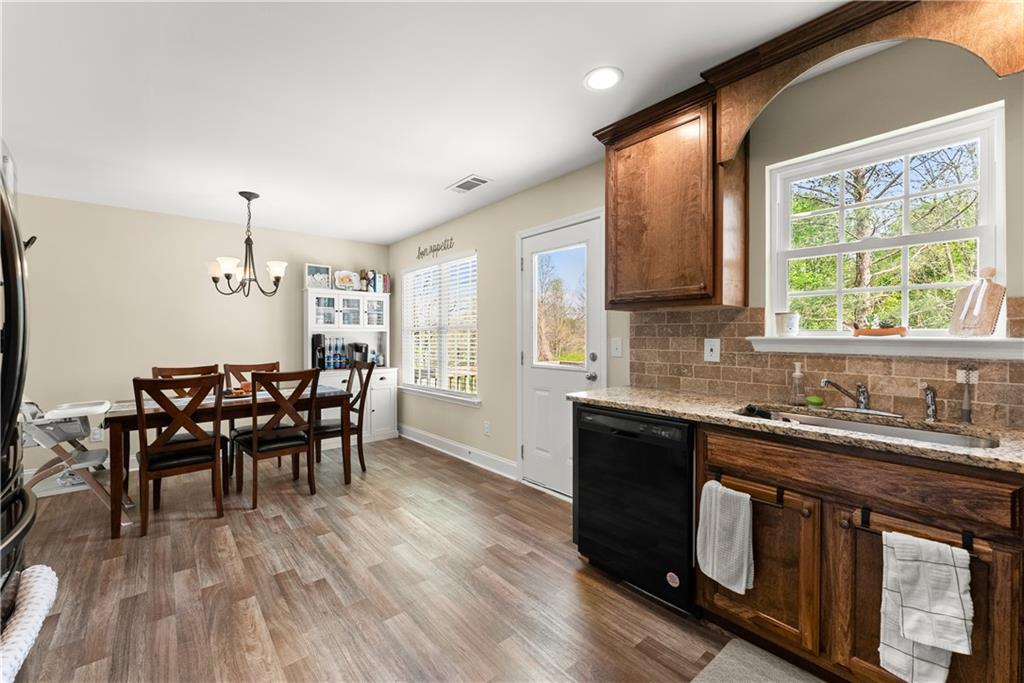 5430 Stepstone Way Gainesville, GA 30506 - Photo 15 of 39 a kitchen with stainless steel appliances granite countertop wooden floor sink stove and dining table