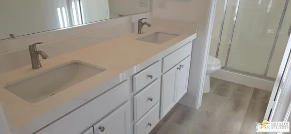 a bathroom with double vanity sink and mirror