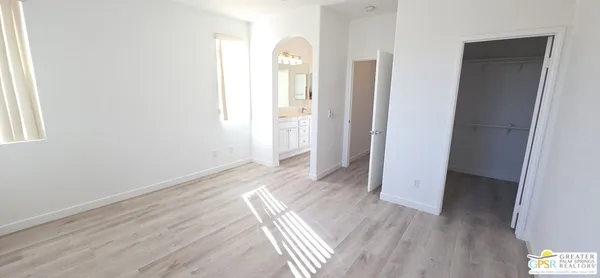 an empty room with wooden floor and window