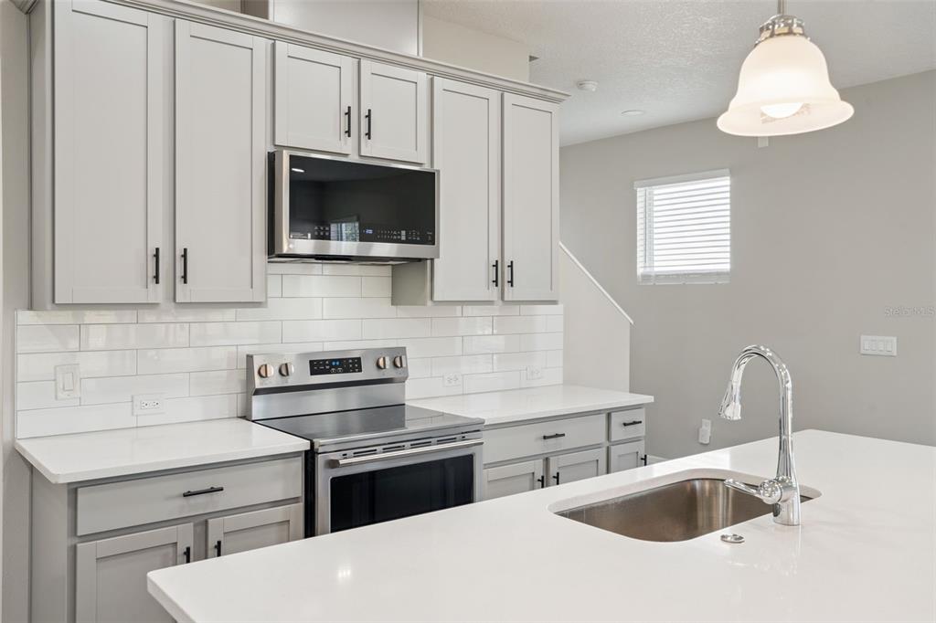 1915 Terrapin Road Ocoee, FL 34761 - Photo 4 of 25 a kitchen with stainless steel appliances a sink a stove and a microwave