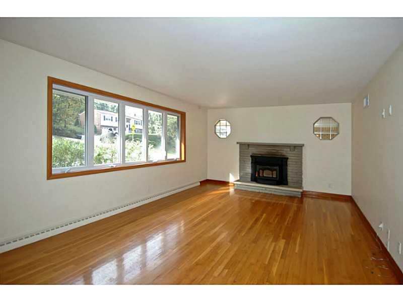 473 Perrymont Road Pittsburgh, PA 15237 - Photo 2 of 25 Living Room. The living room features a gigantic window, a stone, wood burning fireplace flanked on both sides by 2 decorative windows. Sunlight floods this room in the afternoon!