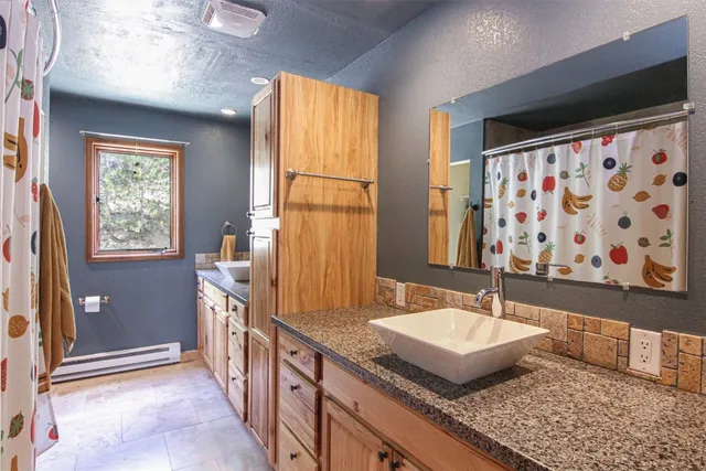 a bathroom with a granite countertop sink and a window
