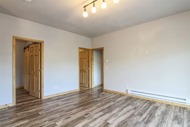 an empty room with wooden floor and a window